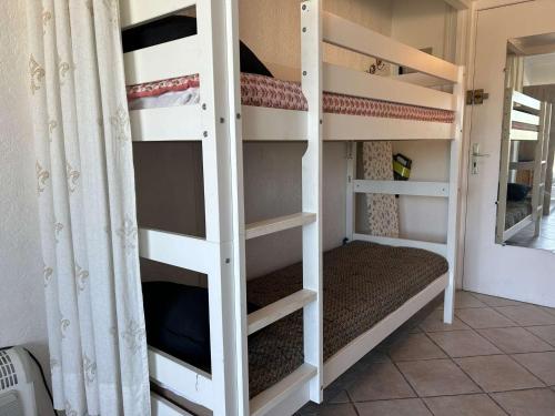 quelques lits superposés dans une chambre dans l'établissement Studio Cabine Climatisé, Plage et Piscine, 4 Couchages - Port Camargue - FR-1-250-151, au Grau-du-Roi
