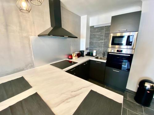 - une cuisine avec un comptoir et une cuisinière four supérieur dans l'établissement Le Marignan By SCLS Locations, à Cannes