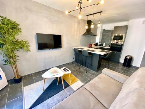 un salon avec un canapé et une cuisine dans l'établissement Le Marignan By SCLS Locations, à Cannes