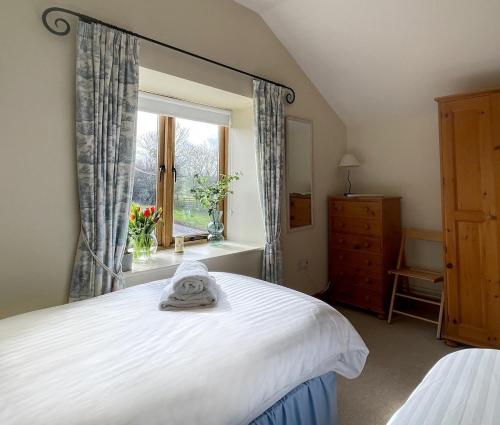 a bedroom with a white bed and a window at Pretty Cottage In Charming Peaceful Village in Kingston