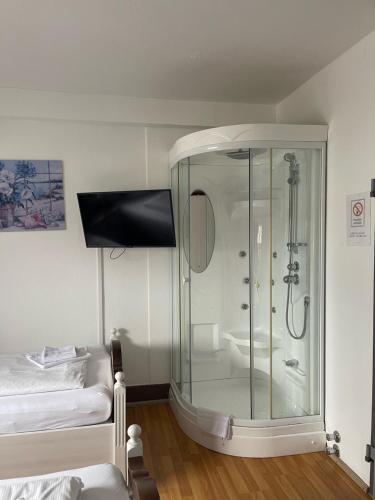 a bathroom with a glass shower and a bed at Linde Restaurant & Hotel in Trossingen