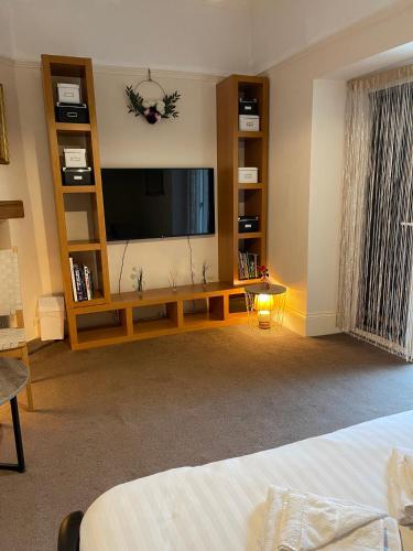 a living room with a flat screen tv and shelves at The Old Rectory in Jarrow