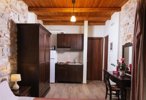 eine Küche mit Holzschränken und einem Tisch im Zimmer in der Unterkunft Hideaway Southcrete in Léntas