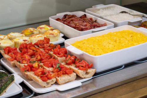 a buffet of food with bread with tomatoes and other foods at Papadopoli Hotel Venezia - MGallery Collection in Venice