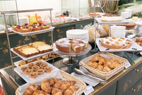 a buffet line with various pastries and cakes and pies at Papadopoli Hotel Venezia - MGallery Collection in Venice