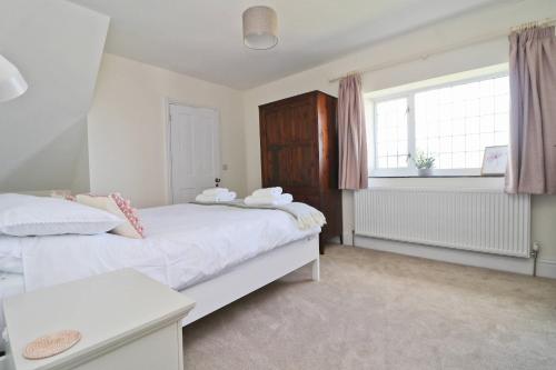 a bedroom with two beds and a window at WALK TO THE BEACH, spacious cottage with sea views in St Merryn