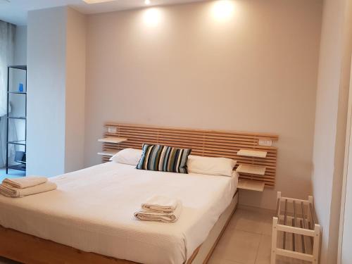 a bedroom with a large bed with a wooden headboard at Modern Flat with lake view & private beach! in Toscolano Maderno