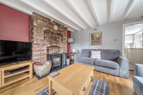 a living room with a couch and a fireplace at Host & Stay - Great Habton Cottage in Malton