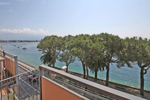 a view of a body of water from a balcony at Modern Flat with lake view & private beach! in Toscolano Maderno