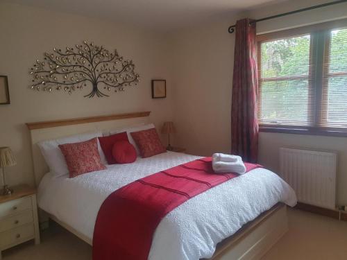 a bedroom with a bed with a tree on the wall at Apartment at Drummond Crescent in Inverness