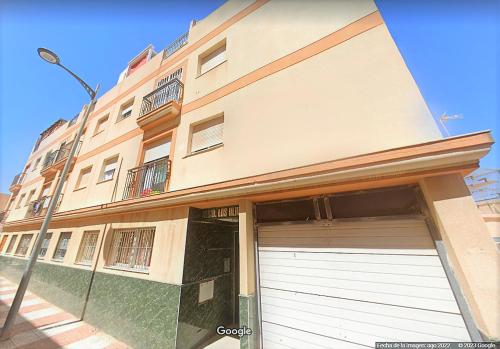 un bâtiment avec une porte de garage devant lui dans l'établissement Ático Roquetas, à Roquetas de Mar