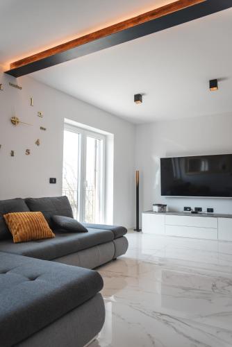 a living room with a couch and a flat screen tv at HIŠA KAPIŠ with HOT TUBE in Koper