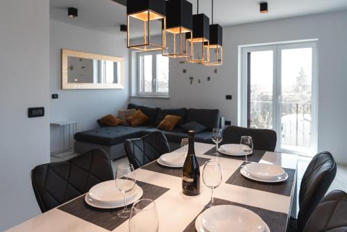 a dining room with a table and a couch at HIŠA KAPIŠ with HOT TUBE in Koper