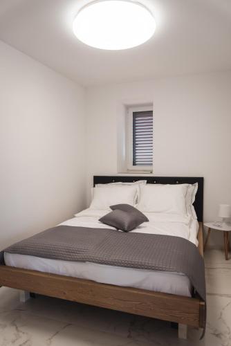 a bedroom with a large bed with white walls at HIŠA KAPIŠ with HOT TUBE in Koper