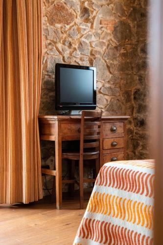 a bedroom with a desk with a television on it at Apartamentos Villa Fresnedo in Solares