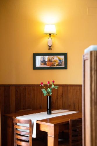 a dining room table with a vase of flowers on it at Apartamentos Villa Fresnedo in Solares