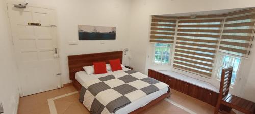 um quarto com uma cama com almofadas vermelhas e uma janela em BROOKLANDS AVENUE em Alappuzha
