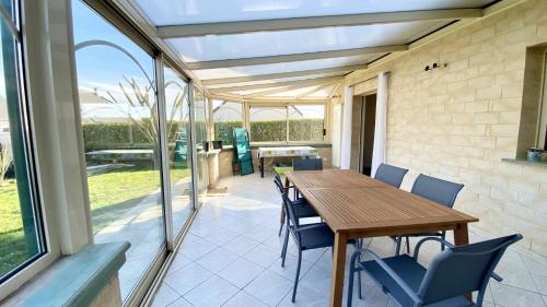 un patio avec une table et des chaises en bois dans l'établissement Chez Sandrine & Tanguy, à Saint-Valery-sur-Somme