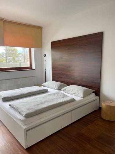 um quarto com uma cama grande e uma cabeceira em madeira em Apartmán Tera em Čeladná