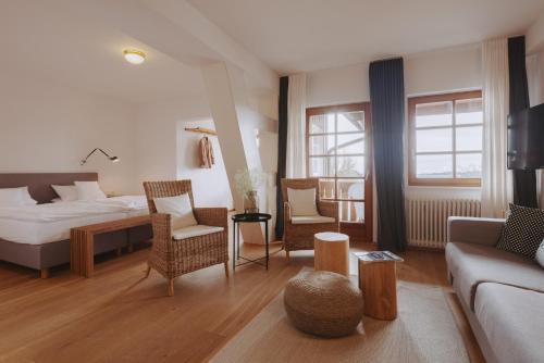ザンクト・メルゲンにあるDer Hirschenのベッドとリビングルームが備わるホテルルームです。