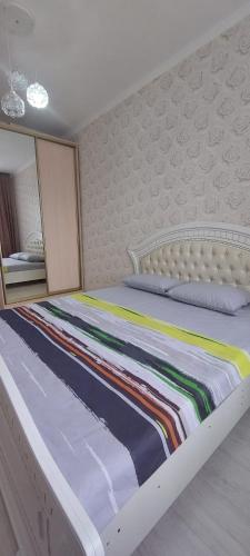 - une chambre dotée d'un grand lit avec un cadre blanc dans l'établissement Апартаменты в новом ЖК АРМАНЕ, à Aqtöbe