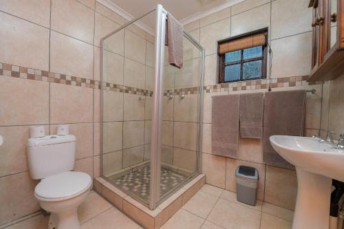 a bathroom with a shower and a toilet and a sink at ATKV Klein-Kariba in Bela-Bela