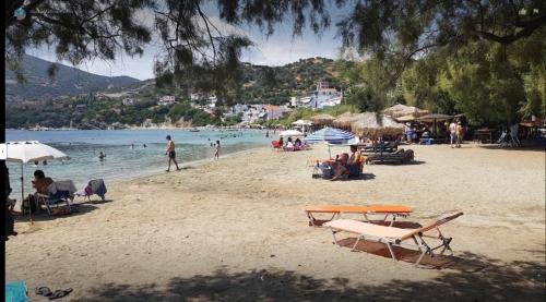 una playa con gente sentada en la arena y el agua en Studio Μαρίνος 'Αγιοι Απόστολοι Πετριές, en Agioi Apostoli