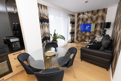 un salon avec une table en verre et des chaises dans l'établissement Apartament Business&Living No 73 z prywatnym jacuzzi zewnętrznym -od maja do września- Nad Zalewem w Cedzynie i miejscem parkingowym, à Cedzyna