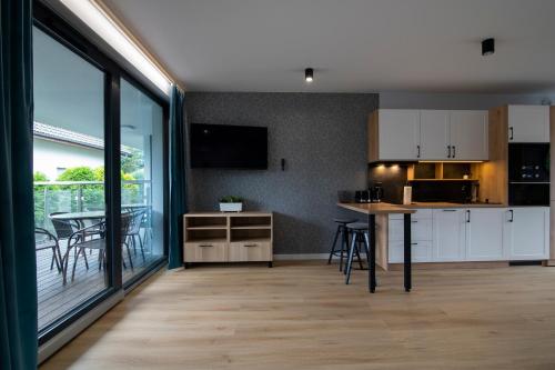 a kitchen with white cabinets and a table with chairs at Kalinowa z sauną, Sun & Snow in Szczyrk
