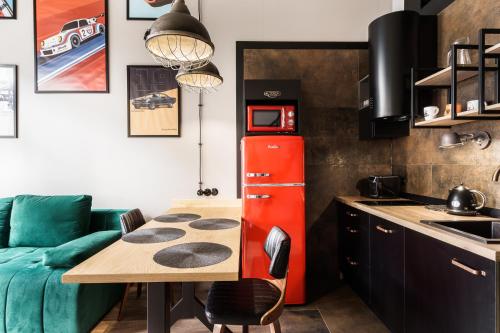 a kitchen with a table and a red refrigerator at RentPlanet - Apartamenty Zarembowicza in Wrocław