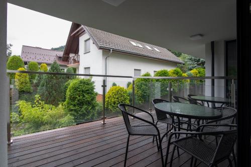 a balcony with a table and chairs on a deck at Kalinowa z sauną, Sun & Snow in Szczyrk