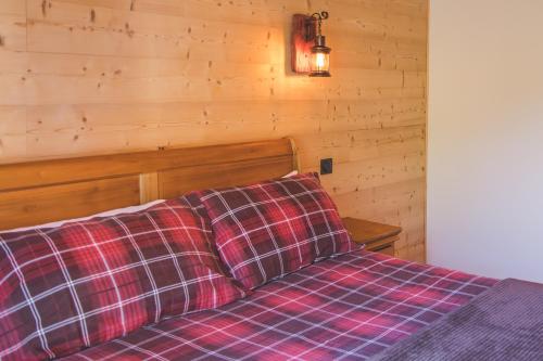 a bedroom with a bed with a plaid blanket at La Masia Del Taulat Chambres d´Hôtes in Llo