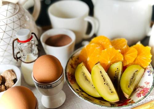 a bowl of fruit and eggs on a table at Les Sources d'Hon - Gîte & Espace wellness in Hon-Hergies