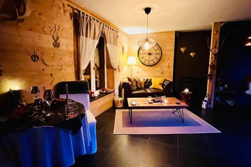 a living room with a table and a couch at Les Sources d'Hon - Gîte & Espace wellness in Hon-Hergies