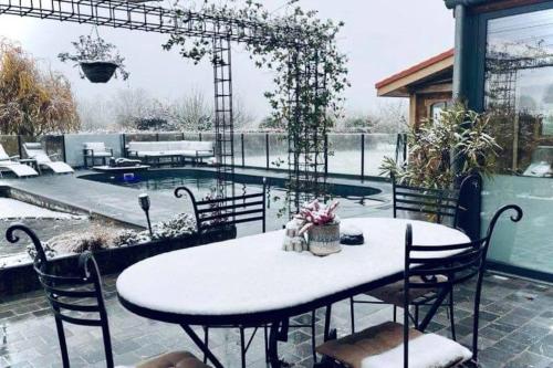 a patio with a table and chairs and a pool at Les Sources d'Hon - Gîte & Espace wellness in Hon-Hergies