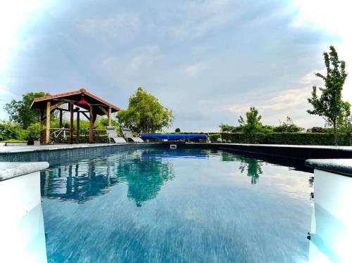 une grande piscine avec un kiosque dans l'établissement Les Sources d'Hon - Gîte & Espace wellness, 
