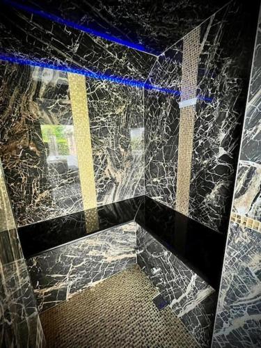 a bathroom with a black and white marble wall at Les Sources d'Hon - Gîte & Espace wellness in Hon-Hergies