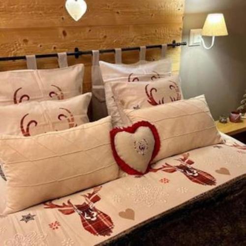 a bed with white pillows with a heart on it at Les Sources d'Hon - Gîte & Espace wellness in Hon-Hergies