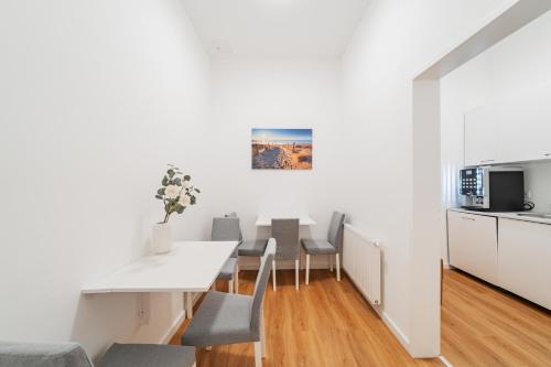 a kitchen and dining room with a white table and chairs at Modern Central City Rooms in Vienna