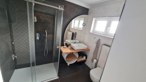 a bathroom with a shower and a sink and a toilet at HIŠA KAPIŠ with HOT TUBE in Koper