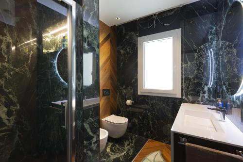 baño con lavabo y aseo y ventana en DSluxury en Pescara