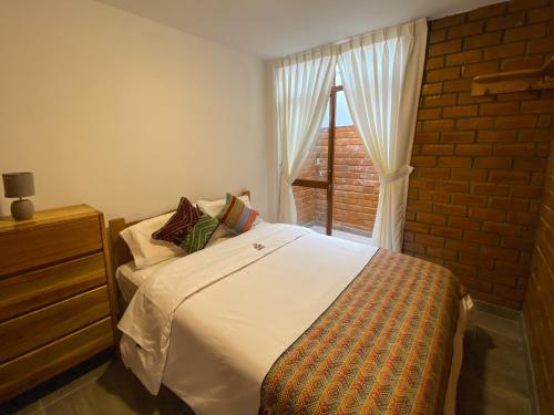 a bedroom with a bed and a window at Tupac Huaraz in Huaraz