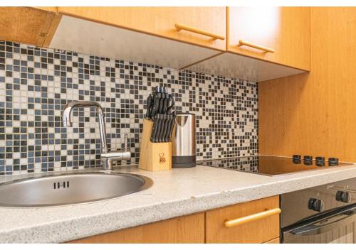 a kitchen counter with a sink and a tile wall at 2 Pleasant Flats - Perfect for Long Stays in Vienna