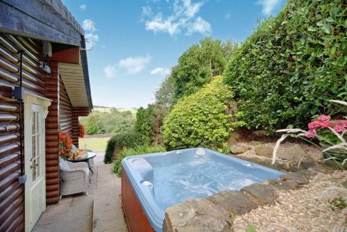 uma banheira de hidromassagem sentada fora de uma casa em Faweather Grange em Bingley