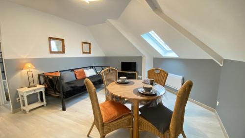 un salon avec une table et des chaises et un lit dans l'établissement Le Viktoria, au Crotoy