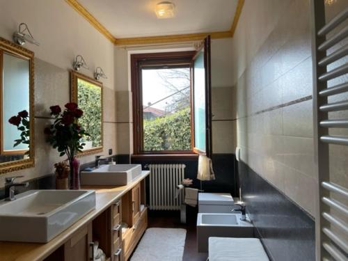 a bathroom with three sinks and two mirrors at Villa Emma in Cremia