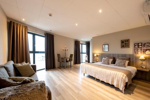 una grande camera da letto con un letto e un divano di Hôtel de la Tour a Melen