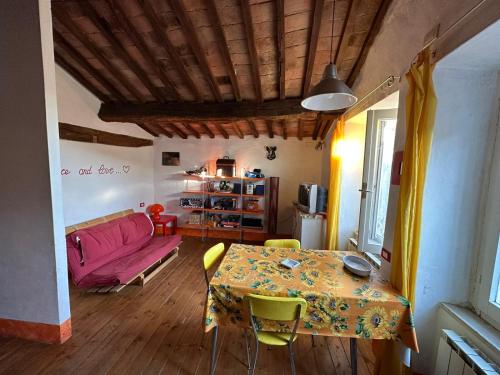 ein Wohnzimmer mit einem Tisch und einer rosa Couch in der Unterkunft Corte delle Oche in Semproniano