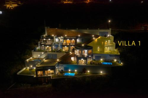 Una casa grande se ilumina por la noche en Skorponeria Bay Luxury Villas, en Skroponeria
