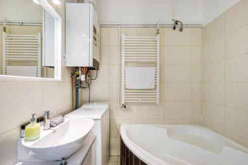 Baño blanco con 2 lavabos y bañera en d.Five Elizabeth Garden Apartment, en Budapest